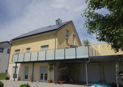 Großer und moderner Balkon mit Balkongeländer aus Stahl und Milchglas von Metallbau Schröder in Schwimbach.
