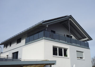 Modernes Balkongeländer aus Milchglas und Edelstahl von Metallbau Schröder in Hilpoltstein.
