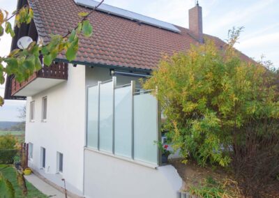 Ein moderner Gartenzaun aus Stahl und Milchglas gefertigt von der Firma Schröder.