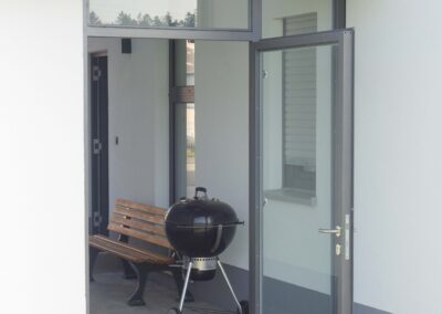 Ein moderner Windfang mit Türe aus Edelstahl von der Firma Metallbau-Schröder in Schwimbach.